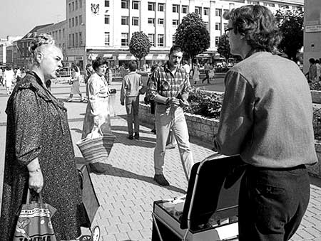 Black and white photo of Ms. Piddington talking to Gibson while Plymouth shoppers look on