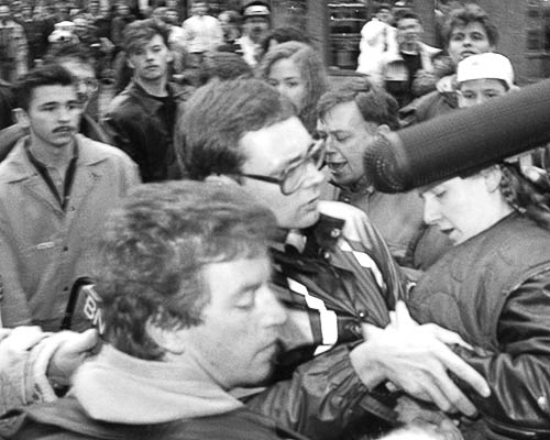 Black and white photo of Paddy, Gibson and Susi being grabbed by protesters