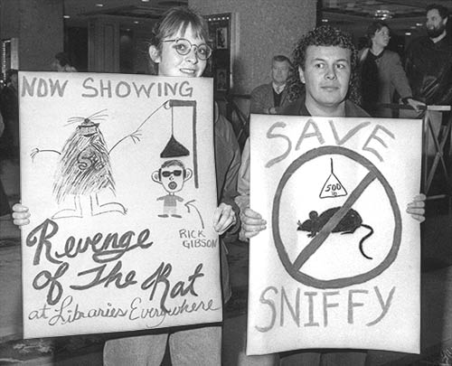 Black and white photo of two protesters holding signs in the lobby of the Hotel Vancouver