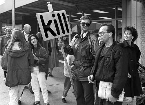 PICTURE: black and white photo of Gibson intereacting with pedestrians and shoppers on Granville street. Photograph by Tom Buhr.